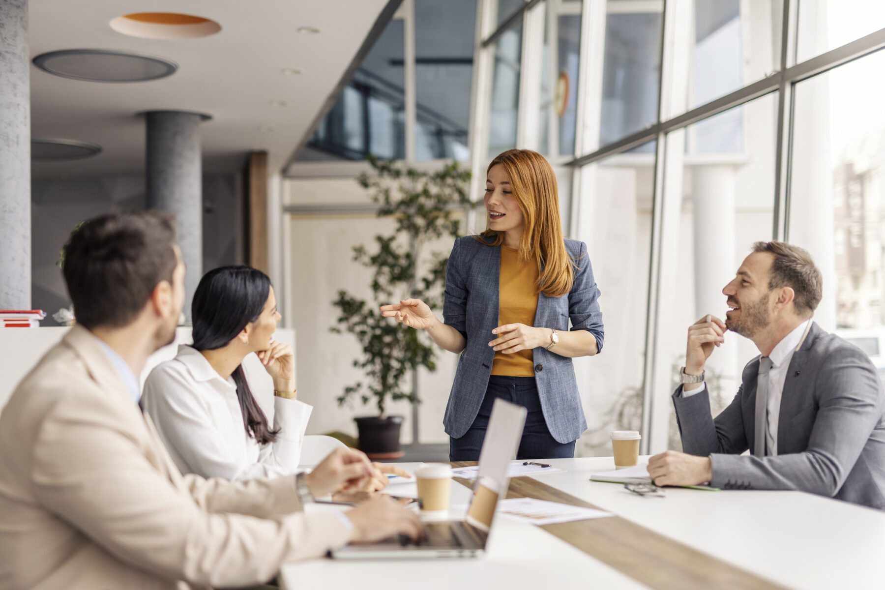 Ein Team bei einem Meeting, Diskussion zwischen zwei Frauen und zwei Männern.