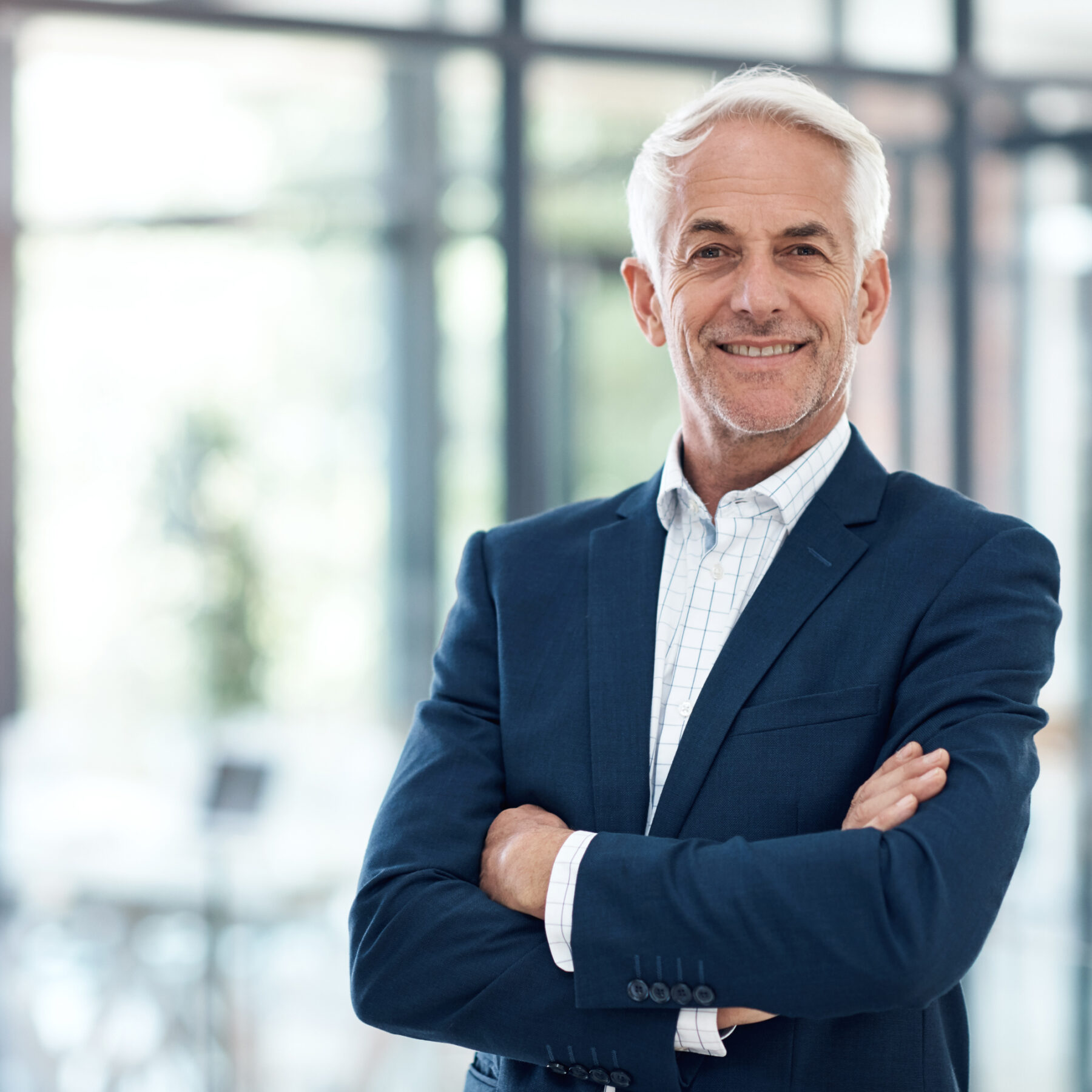 Porträt eines selbstbewussten reifen Geschäftsmannes, der in einem modernen Büro arbeitet