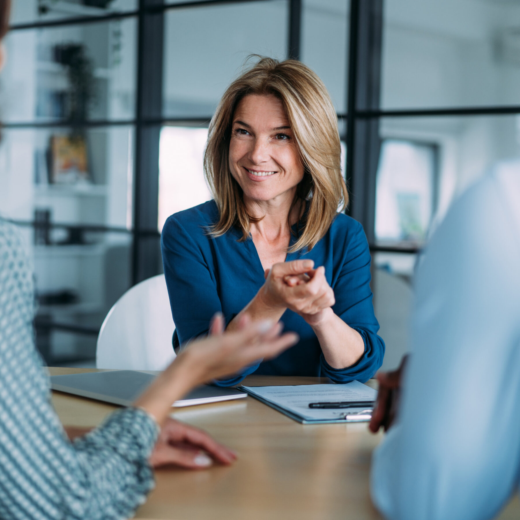 Shot of group of business persons in business meeting. Three persons on meeting in board room. Business team on meeting in modern office. Female manager discussing with her colleagues.