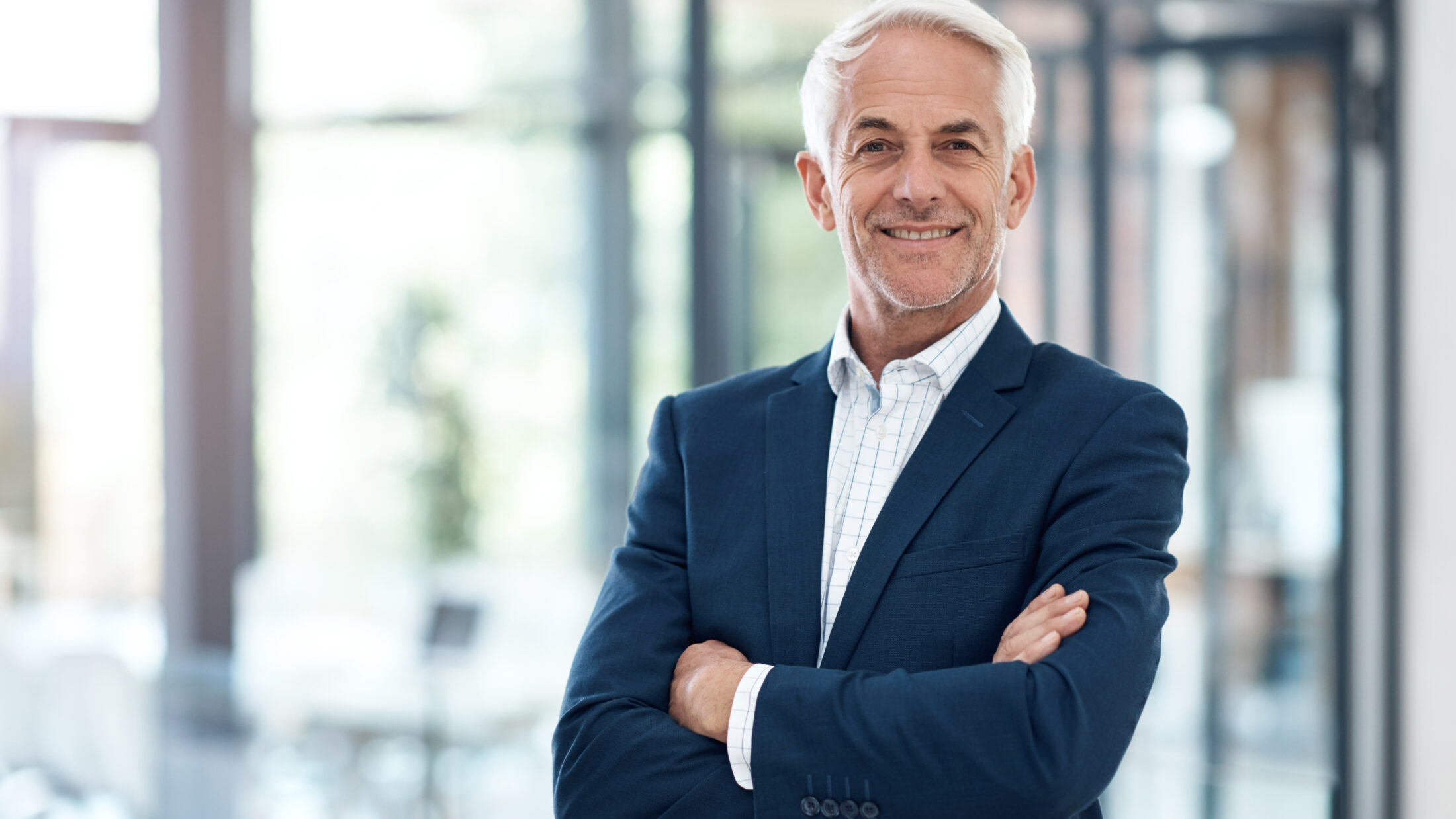 Porträt eines selbstbewussten reifen Geschäftsmannes, der in einem modernen Büro arbeitet