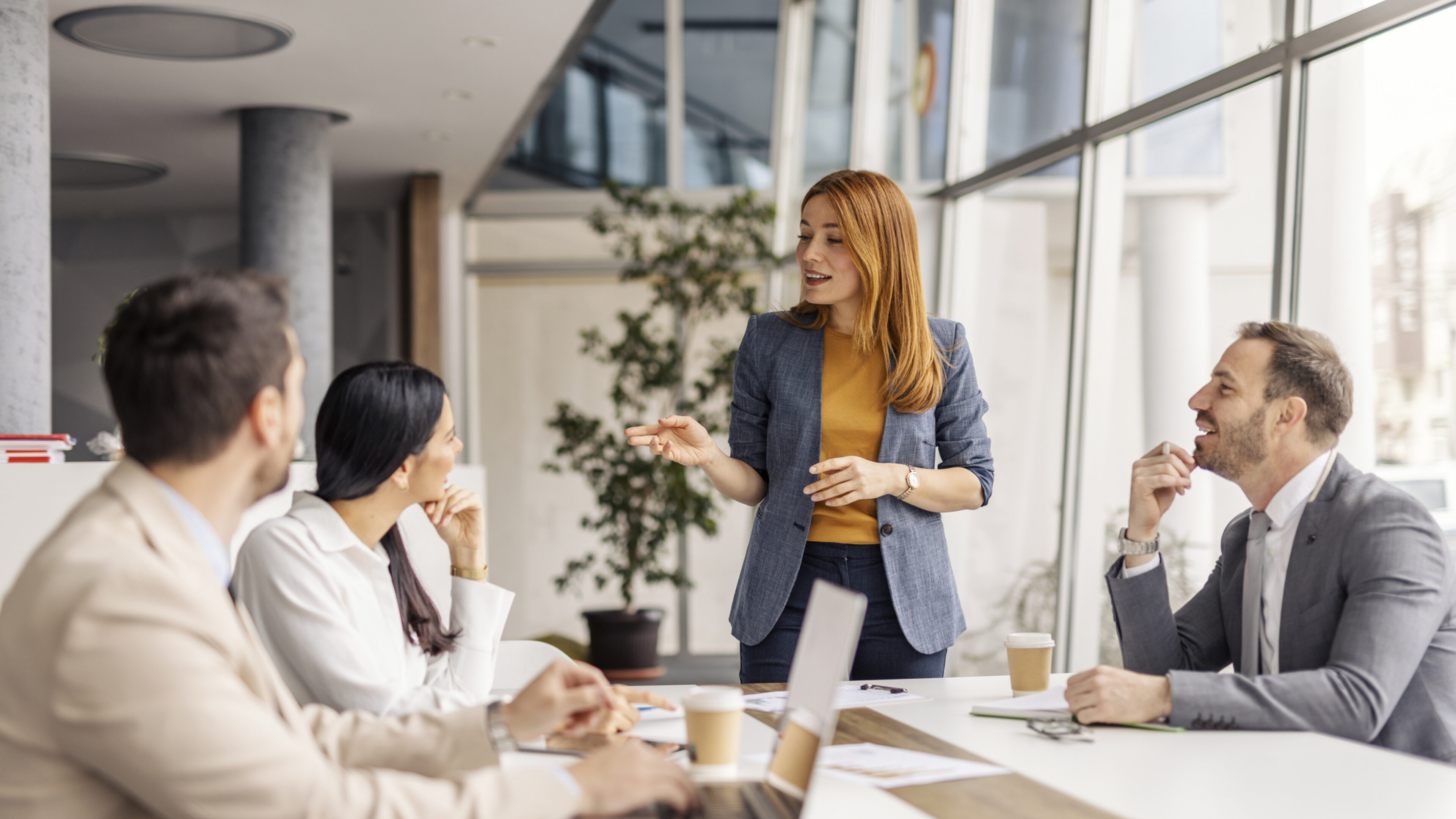 Ein Team bei einem Meeting, Diskussion zwischen zwei Frauen und zwei Männern.